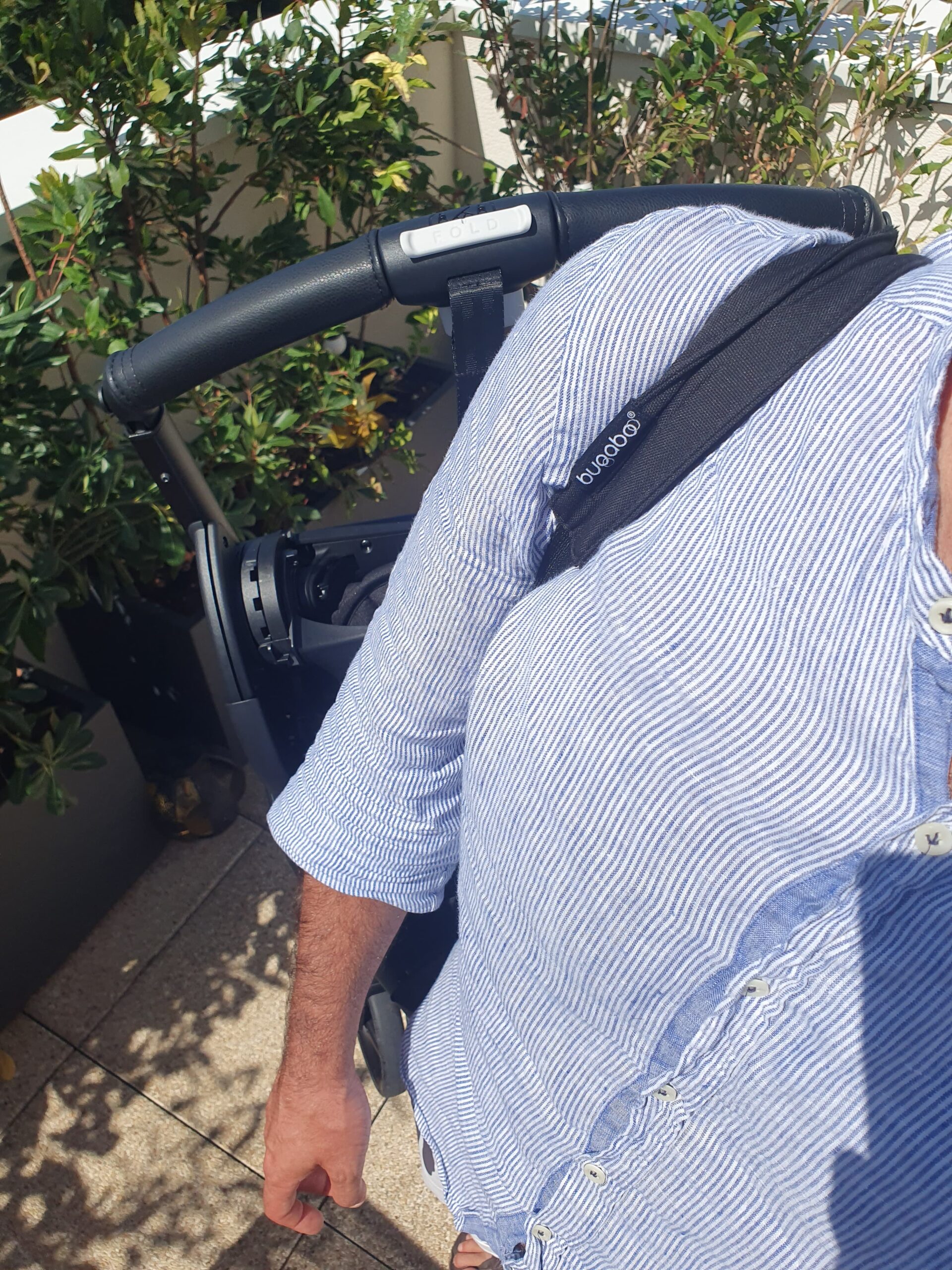 La poussette Dragonfly de Bugaboo portée sur l'épaule.